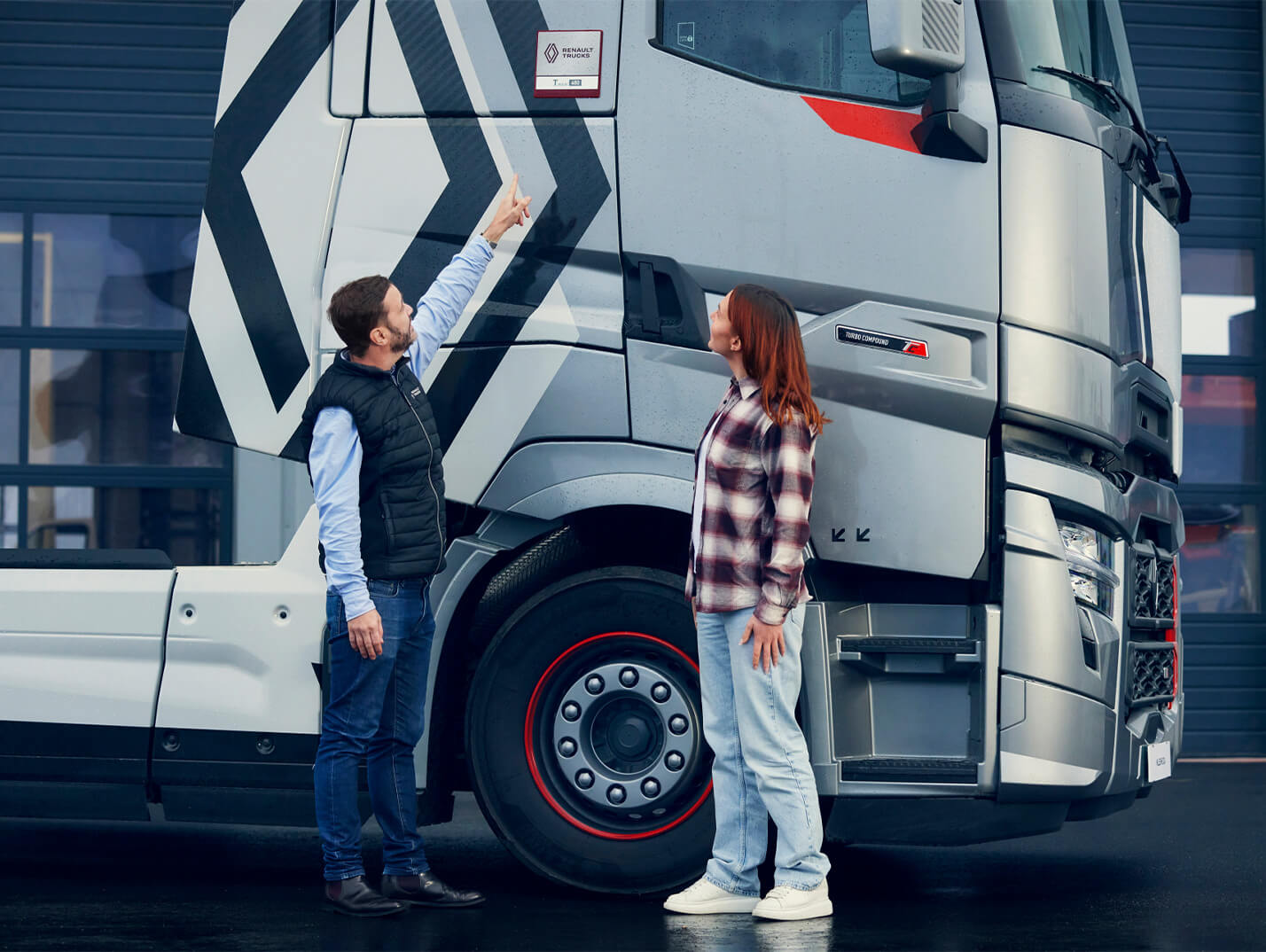 Deux personnes sur le côté droit d'un Renault Trucks T High gris