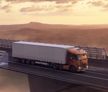 A right-hand-drive Renault Trucks T High pulls a semi-trailer across the Millau Viaduct at sunset, overlooking a spectacular sea of clouds.